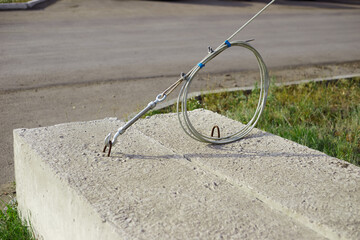 the turnbuckle rope is held by a heavy building block, a counterweight to the post