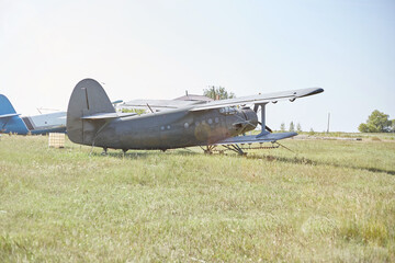 An old Soviet AN 2 aircraft stands at the airfield in the green