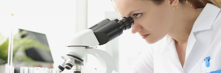 Adult caucasian beauty woman chemist looking at microscope