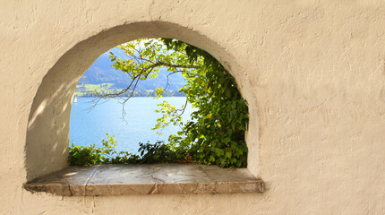 View of Wolfgangsee lake through the window in the medieval fortress wall, Austria