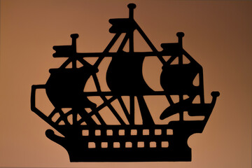 Stylized silhouette of a sailing ship on a brown background.