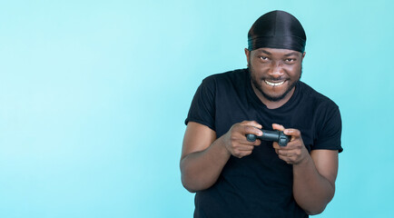 Gamer fun. Rapper man. Cyber entertainment. Happy guy in go-rag playing online using console isolated blue copy space.