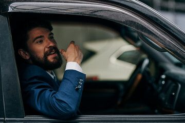 bearded man in a car suit driving around the city