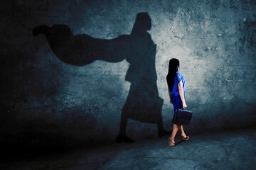 Female manager walking with superhero cape shadow - obrazy, fototapety, plakaty