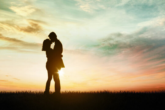 Silhouette of young couple kissing and embracing
