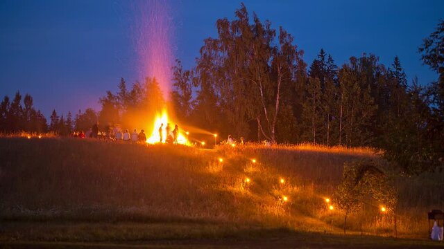 timelapse of group of people getting together into the nature, around big campfire at night