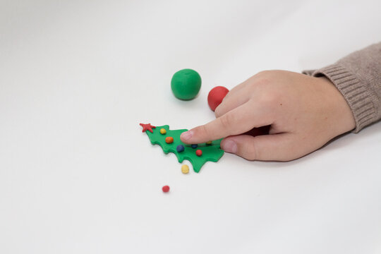 Child makes a toy tree from plasticine