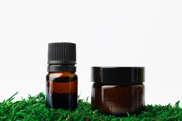 Bottle of aromatic oil for herbal medicine among natural green moss