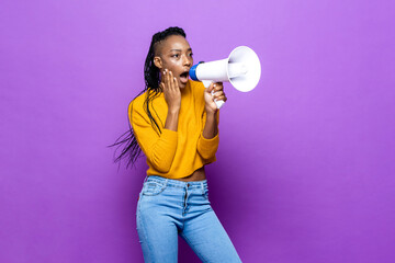 Shocked African American woman holding megaphone in purple color isolated background