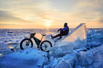 Man ride bicycle on the frozen lake.