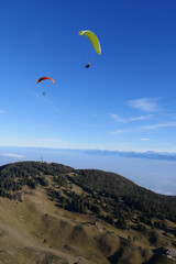 Fototapeta na wymiar Paraglider flying over mountains in summer day in front of the mountain, High quality photo