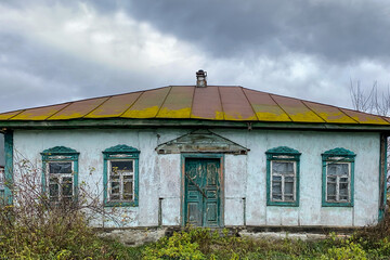 Old empty abandoned house with wooden windows in village or countryside. Close-up.