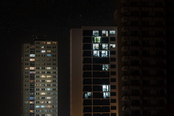Fototapeta na wymiar Beleuchtete Fenster von Hochhäusern in der Nacht