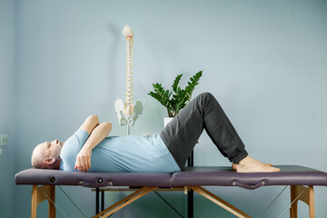 A man lying on the massage table in constructive rest postion