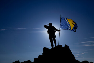 Silhouette of an unrecognizable soldier with the Bosnian flag