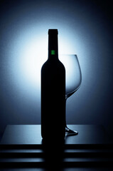 Bottle of red wine and an empty glass.