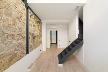 Mix of new and old architecture of Barcelona. Refurbished apartment with restored ancient wall left...