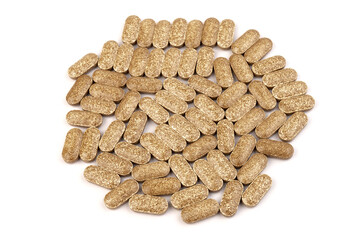 Nutrition supplements, brown vitamin pills on white background.