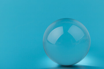 Crystal glass ball sphere transparent on blue background.