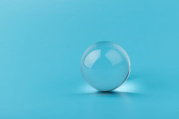 Crystal glass ball sphere transparent on blue background.