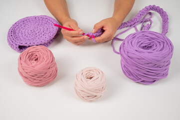 Close-up of a woman crocheting a basket of cotton yarn.