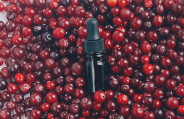 Glass bottle with liquid, serum or essential with cranberry. Health and medicine concept, beauty and selfcare. Top view, copy space