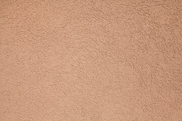 Brown (coffee) wall, texture, background. Plastered building wall, painted with water-based paint. Decorated surface with embossed pattern and strokes in abstract style. Elements of exterior, interior
