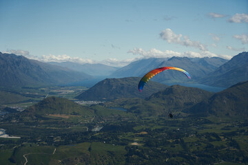 paraglider over the mountains and blue sky enjoying the view
