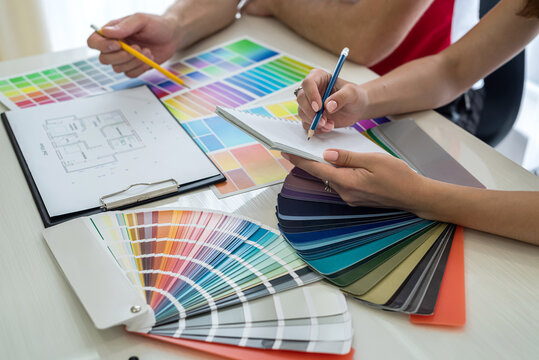 Designers working with apartment sketch and colour pattern