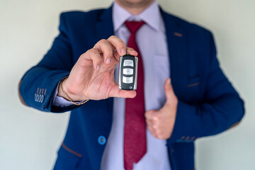 businessman gives the keys to the car. buy or rent concept