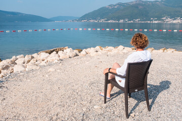 Fototapeta premium Woman relaxing on a beach chair. Vacation and holidays concept. Tivat, Montenegro