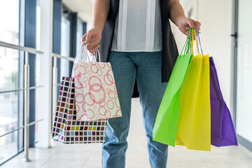 Young woman with shopping bags inside shopping center black friday