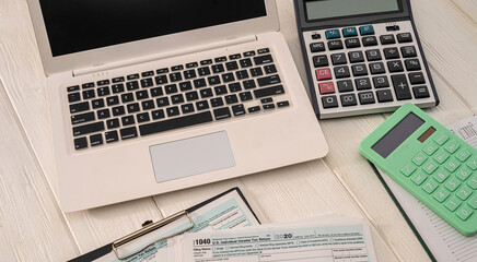 new laptop two calculators and blank blank tax form usa 1040 with tablet lying on the table