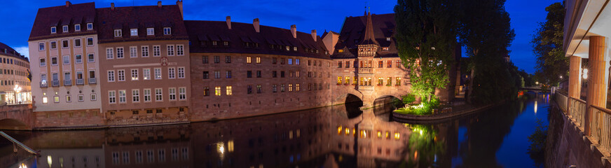 Fototapeta premium Nuremberg. Old stone buildings above the canal at sunset.