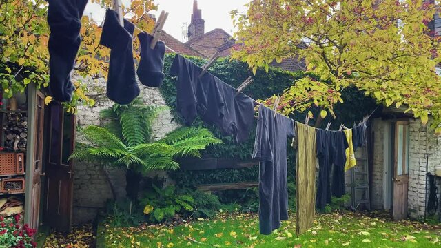 Mens clothing hang to dry on an outdoor clothing line in London, England.