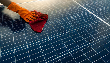 Man cleaning solar panel on roof. Solar panel or photovoltaic module maintenance. Sustainable...