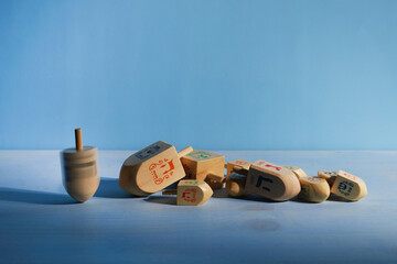 Jewish holiday Hanukkah with wooden dreidels, spinning top