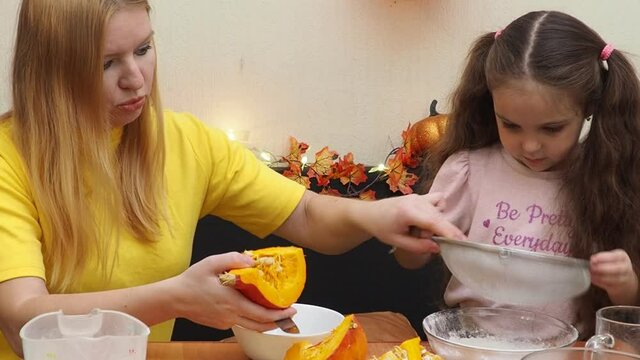 Mam And Daughter Are Making Dough pie For Thanksgiving Pie. put the dough in a mold for a thanksgiving pumpkin pie. Process of making Pumpkin pie for Thanksgiving Day. Seasonal traditional autumn fest