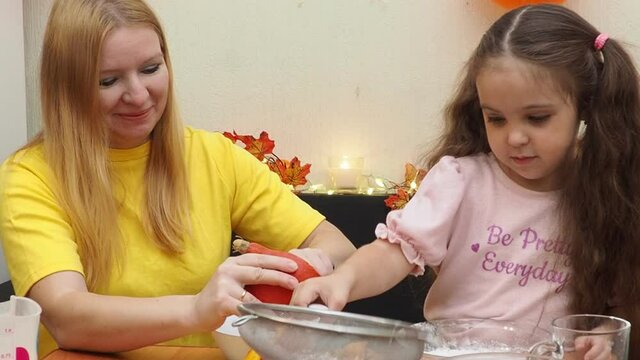 Mam And Daughter Are Making Dough pie For Thanksgiving Pie. put the dough in a mold for a thanksgiving pumpkin pie. Process of making Pumpkin pie for Thanksgiving Day. Seasonal traditional autumn fest