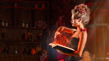 Charming woman witch flowers in hair vintage black dress with book of spell in the old castle....