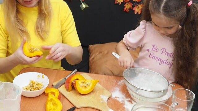Mam And Daughter Are Making Dough pie For Thanksgiving Pie. put the dough in a mold for a thanksgiving pumpkin pie. Process of making Pumpkin pie for Thanksgiving Day. Seasonal traditional autumn fest