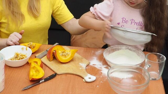 Mam And Daughter Are Making Dough pie For Thanksgiving Pie. put the dough in a mold for a thanksgiving pumpkin pie. Process of making Pumpkin pie for Thanksgiving Day. Seasonal traditional autumn fest
