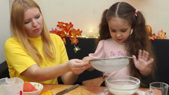 Mam And Daughter Are Making Dough pie For Thanksgiving Pie. put the dough in a mold for a thanksgiving pumpkin pie. Process of making Pumpkin pie for Thanksgiving Day. Seasonal traditional autumn fest