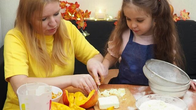 Mam And Daughter Are Making Dough pie For Thanksgiving Pie. put the dough in a mold for a thanksgiving pumpkin pie. Process of making Pumpkin pie for Thanksgiving Day. Seasonal traditional autumn fest