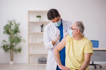 Fototapeta premium Old male patient visting young male doctor in vaccination concep