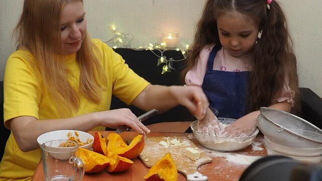 Mam And Daughter Are Making Dough pie For Thanksgiving Pie. put the dough in a mold for a thanksgiving pumpkin pie. Process of making Pumpkin pie for Thanksgiving Day. Seasonal traditional autumn fest