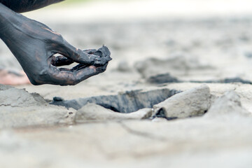 Hand with mineral mud from a pit for cosmetic and medical procedures.