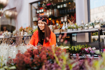 Smiling woman looking at flowers on retail display