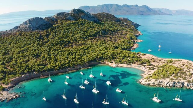 Yacht near the green island in Greece. Luxury vacation at sea.