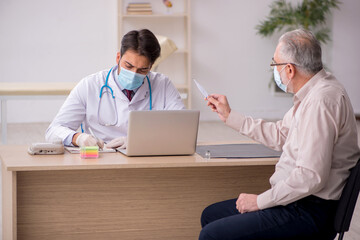 Obraz premium Old male patient visiting young male doctor in vaccination conce
